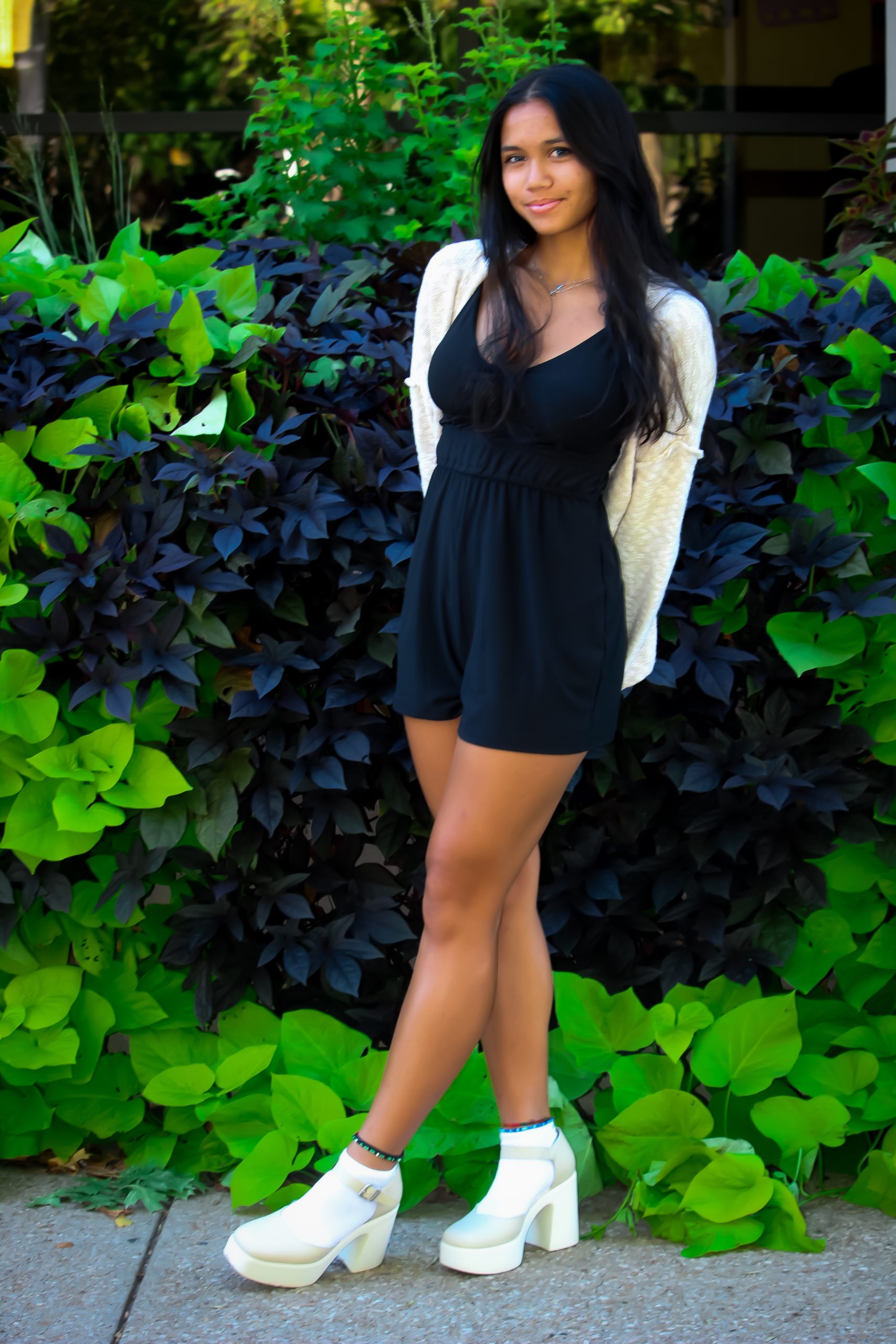 Girl standing in front of blue and navy leaves