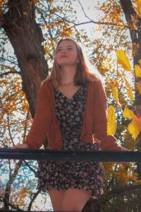 Girl leaned on railing over camera